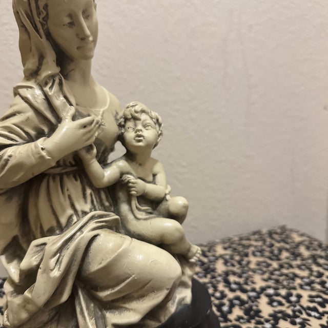 This beautiful vintage statue depicts the Virgin Mary cradling the Christ Child, a pose famously captured in...