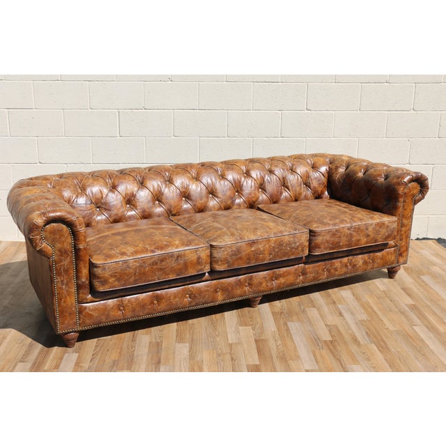 A timeless Chesterfield silhouette reimagined with an industrial edge, this three-seat sofa showcases richly distressed...