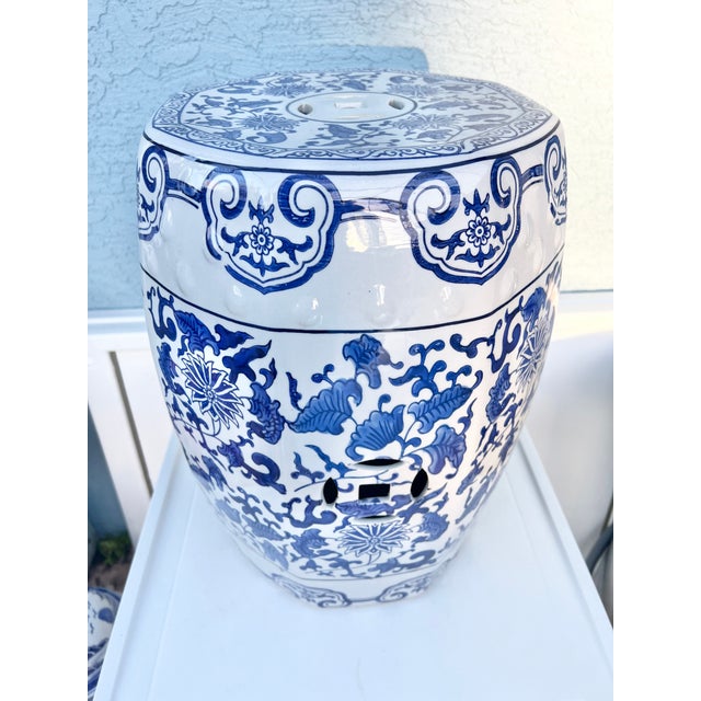Hand-painted with vibrant floral and butterfly motifs, this glazed stool doubles as a charming side table. Its rich blue...