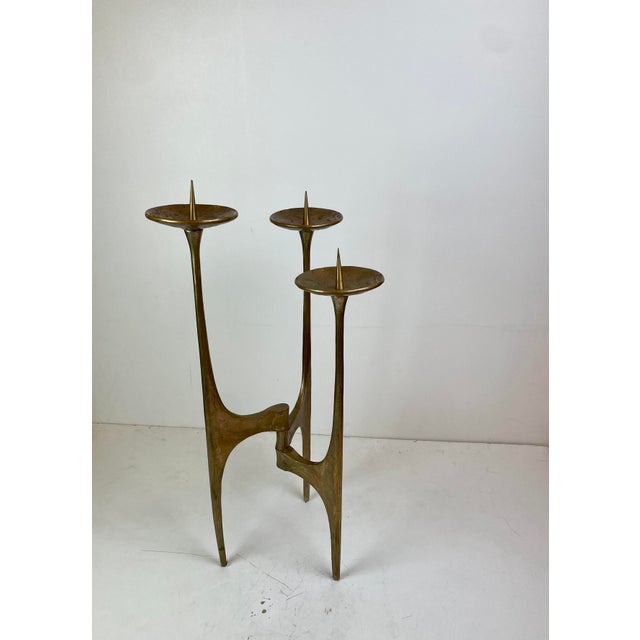 Sculptural Brutalist floor candle holder crafted in solid cast bronze, featuring three elongated organic branches that...