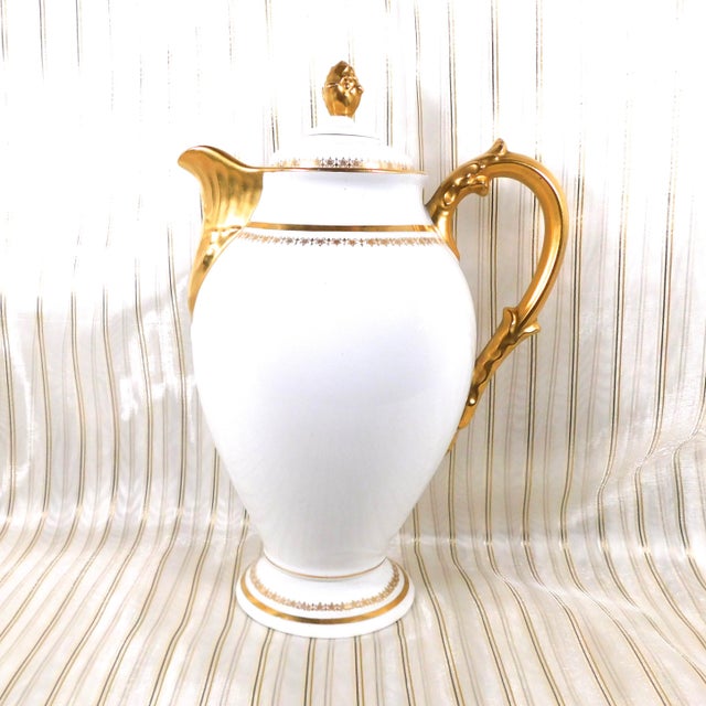 This is a Deliniers and Cie Limoges chocolate pot or coffee pot in an unkinown pattern. The pot is shiny white with gold...