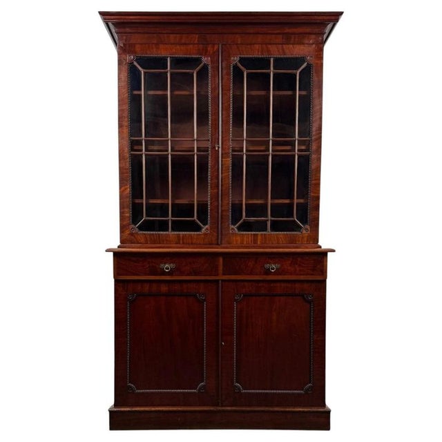 An impressive 19th-century English bookcase in the Regency style, finely constructed from richly figured mahogany and...