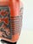 A striking vintage Chinoiserie-style table lamp featuring a rich red-orange ceramic body accented with raised black floral...