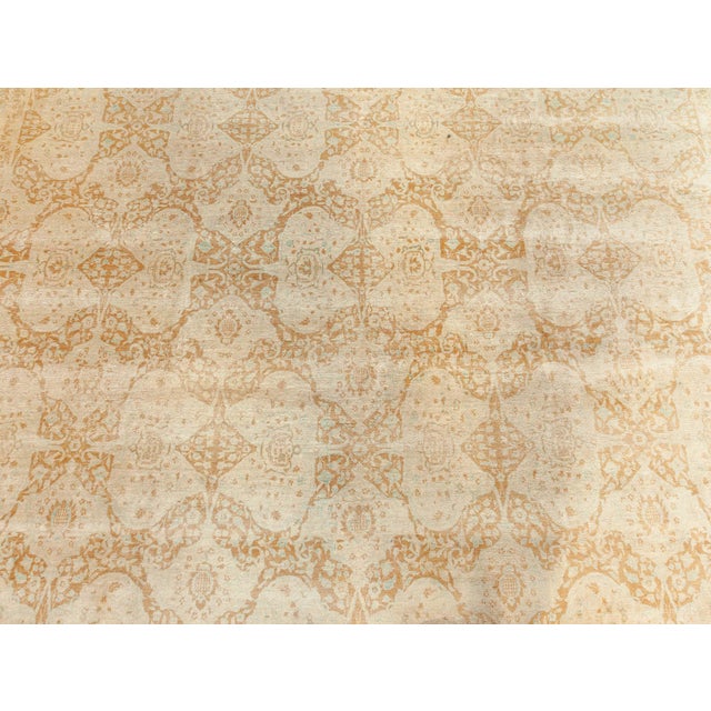 A hand-knotted wool antique Indian rug dating back to 1920. The main field features floral abstractions and vines enclosed...