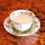 An associated cup and saucer, the cup very finely decorated with handpainted flowers and gilt filets, the saucer with an...