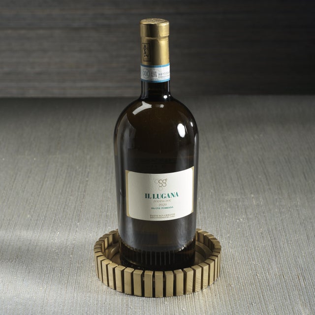 A sleek and striking addition to any wine presentation, this round stainless steel wine bottle coaster features a matte...