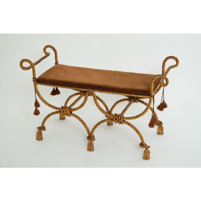 Decorative Hollywood Regency bench made of gilded wrought iron, Italy, 1950s. Heavy gilded iron bench with double curule...