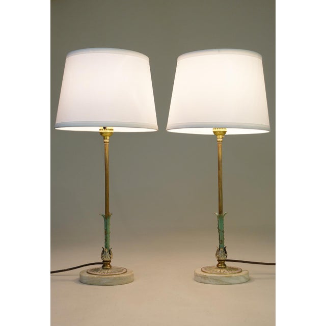 A brilliant and striking pair of slender Streamline Art Deco styled French Empire Brass & Travertine Marble candlestick...