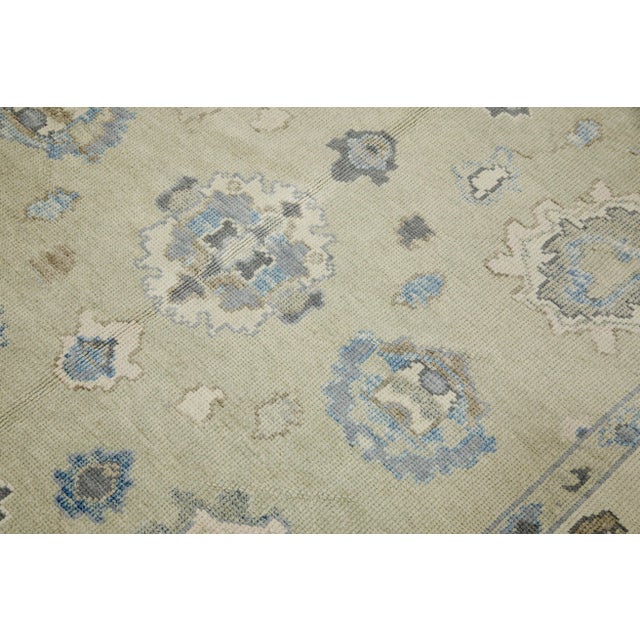 This modern Turkish Oushak rug is a stunning piece of art that has been handwoven using traditional techniques by skilled...