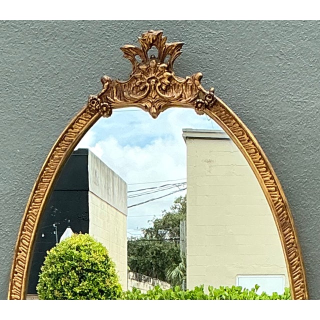 This vintage Rococo-style wall mirror captures the opulent elegance of 18th-century European design through its...