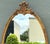 This vintage Rococo-style wall mirror captures the opulent elegance of 18th-century European design through its...
