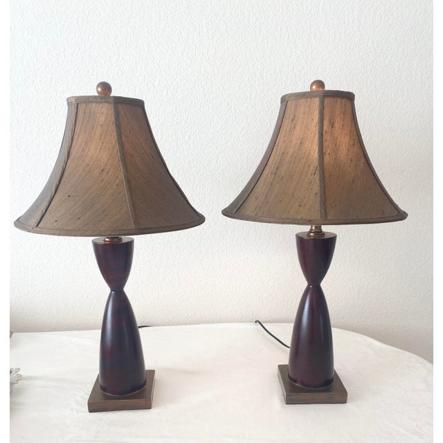 Vintage Hourglass “Turned” Shaped Two-toned Dark Pair of Lamps. Measures 28.5 inches in height, 16 inches in width and 16...