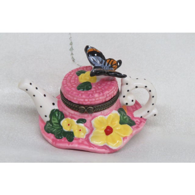 This lovely small Trinket Box is made of ceramic. This trinket box has a teapot hat shape, with butterfly on the top and...