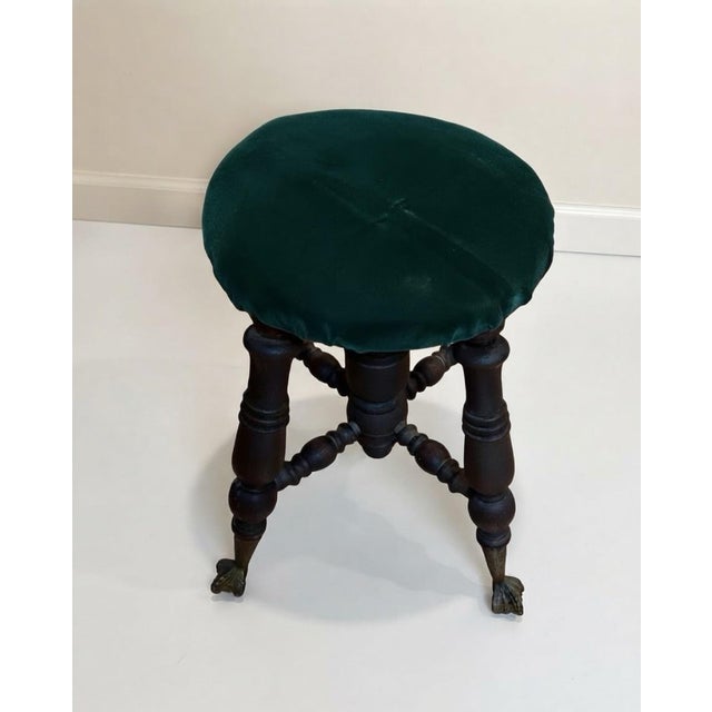 A charming antique-style Victorian stool featuring an elaborately turned dark wood base supported by four distinctive...