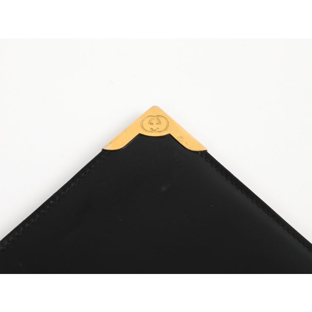 Gucci black leather portfolio folder, circa 1980s. Two gold corners stamped with Gucci double-G logo, and gold interior...