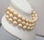 1980s or 1990s goldtone 3-strand off-white faux-baroque pearls collar necklace with hook clasp. Marked "©Monet" on the...