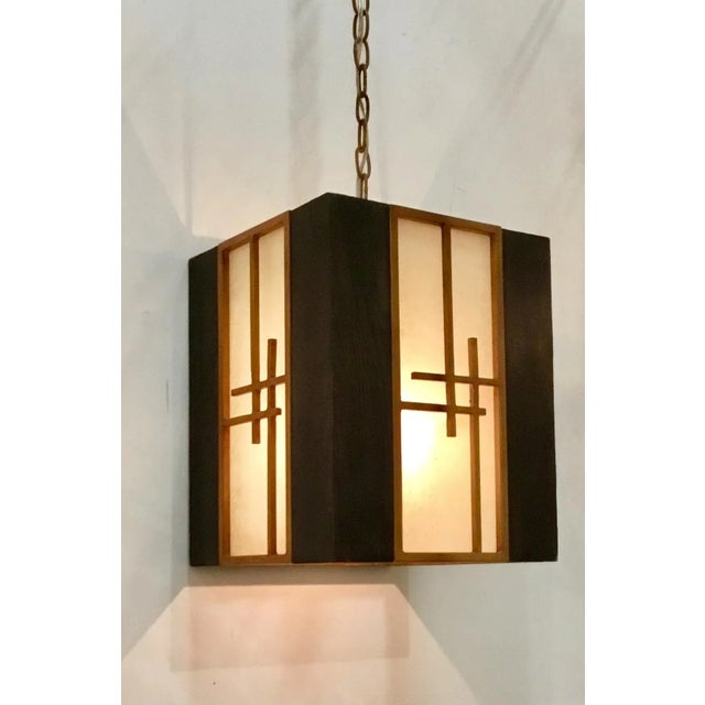 Stylish Currey & Co. Asian Modern Kiyamacki Lantern from the Koshi Collection, carved wood with frosted glass panels, one...