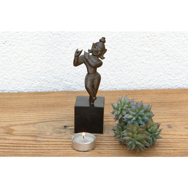 A masterfully modeled small-scale devotional casting capturing a dynamic cross-legged stance, an incised ritual waist...