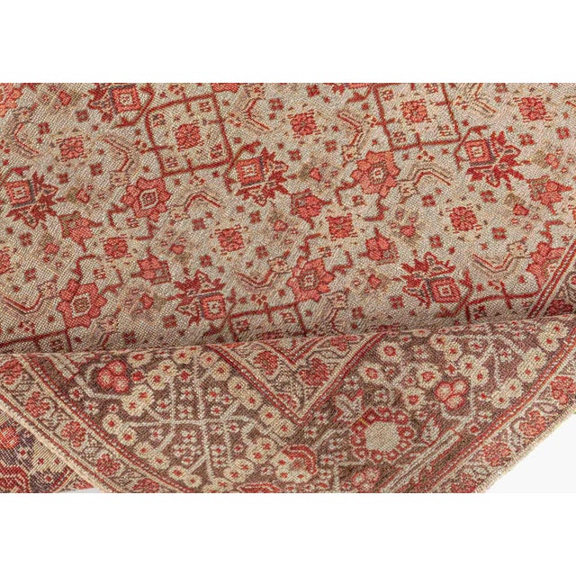 A hand-knotted wool antique Persian rug dating back to circa 1930. It is exemplary both in design and execution. An all...