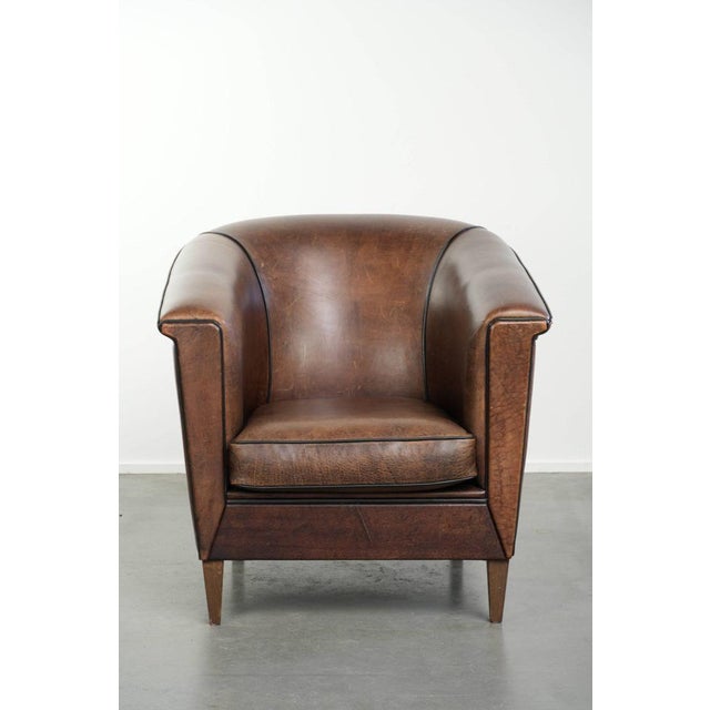 This sleekly designed sheepskin club armchair in elegant Art Deco style features a loose seat cushion and is stylishly...