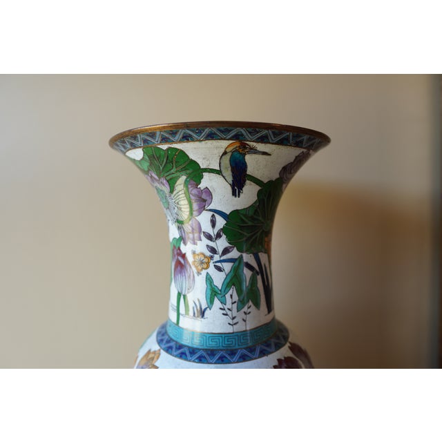 This tall decorative vase features a classic silhouette accented with green and purple decorative detailing, making it a...