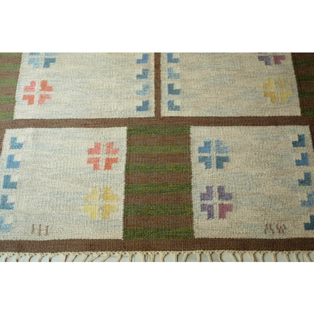 Vintage Swedish Kilim rug in a design by Alice Wallebäck and weaved by signature HH. Beautiful repeated geometric and...