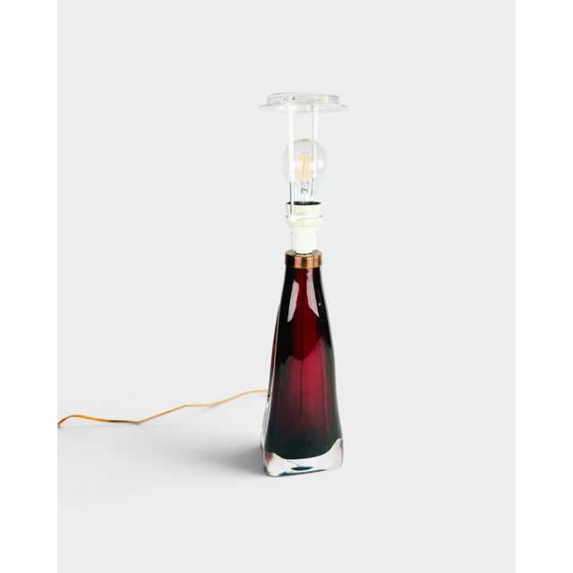 Elegant table lamp by the renowned Swedish glass manufacturer Orrefors, crafted from thick art glass using a red cased-...