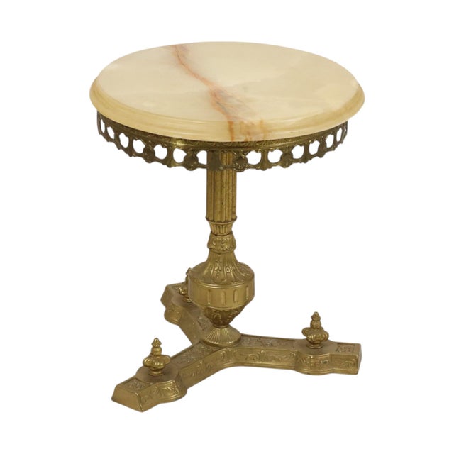 A vintage side table in Baroque or Rococo style—a classic plant stand featuring a brass base and a round onyx marble top....