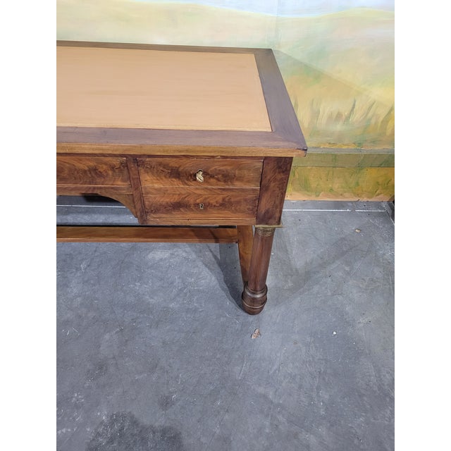 Late 19th-century Empire-style mahogany flat desk The top is covered in light leather, gilt-trimmed around the edges. The...