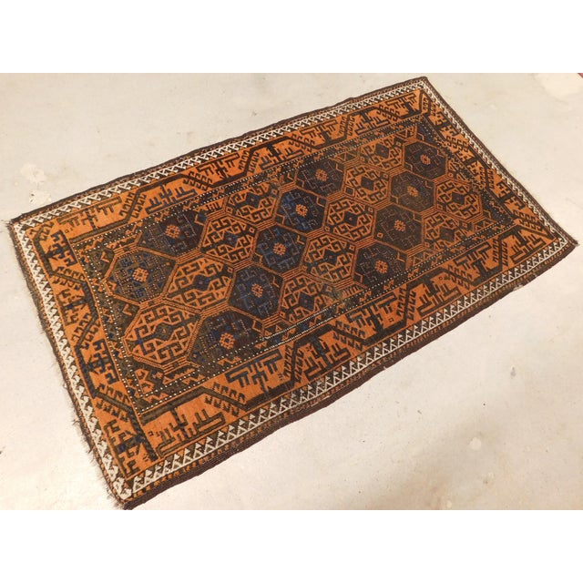 A rare Antique Persian Baluchi Tribal rug, displaying geometric panels on a rust background. Wool pile on wool foundation.