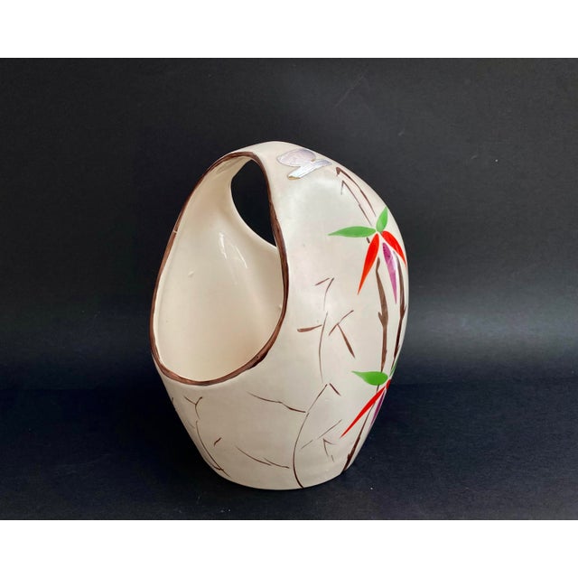 A collectible porcelain vase of an unusual shape, decorated with gilded decor depicting elegant flowers from the Laeken...