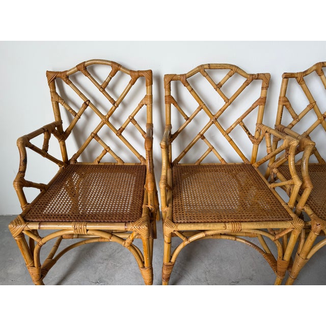 Elegant set of four Italian rattan dining chairs crafted in a classic Chippendale-style lattice design, showcasing...