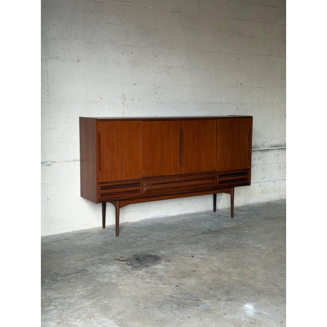 This impressive sideboard features smooth sliding doors, interior shelving, and a built-in dry bar area with a mirrored...