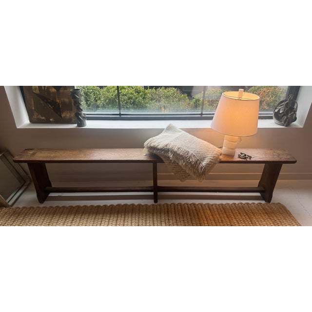 Vintage long and narrow wooden bench from France. This dark wood rustic bench would be fantastic in a hallway or at the...