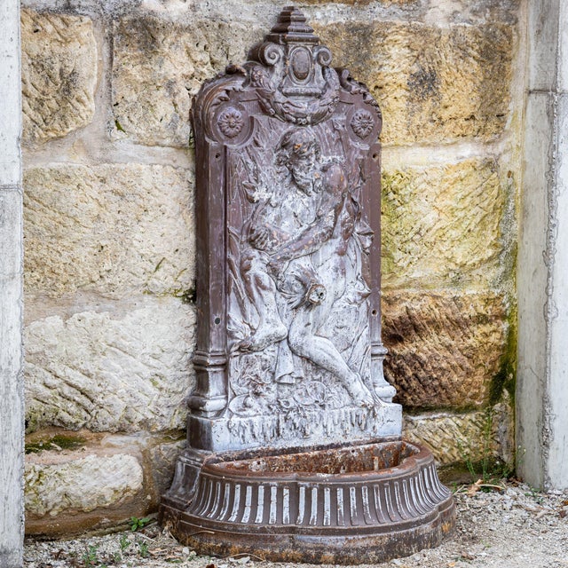Wall fountain made of patinated metal with a detailed relief back panel. The figurative depiction and finely crafted...