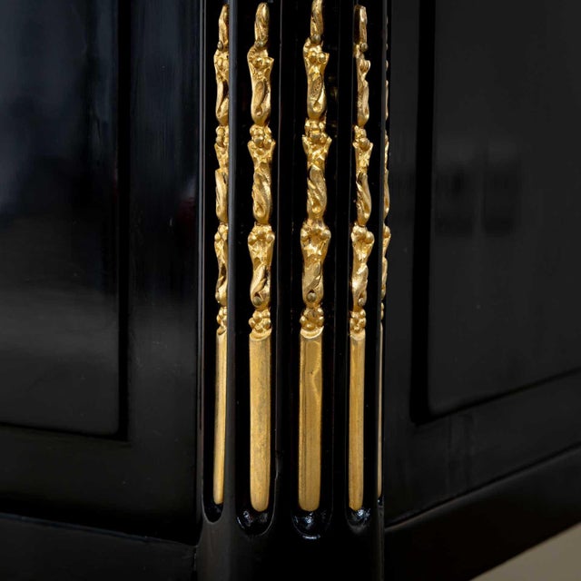 A neoclassical ebonised three-drawer commode with a white marble top with rounded corners. The corners of the chest are...