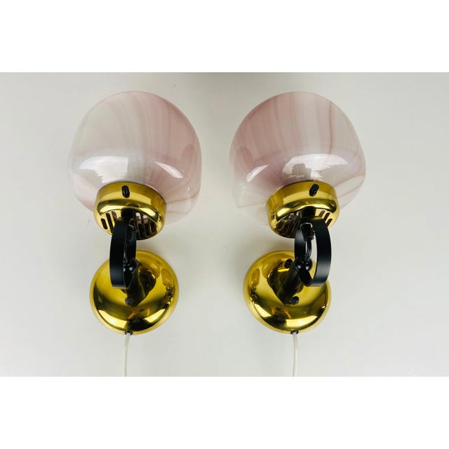 Peill & Putzler sconces made in Germany in the 1970s. White and pink opaque glass with brass elements. The lamps are in a...