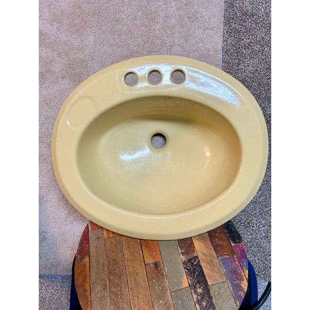 Vintage 1979 porcelain bathroom sink. Lovely pale yellow, butter, light harvest color. Self rimming drop in sink features...