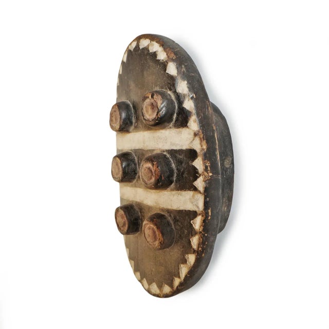 Vintage Grebo carved wood mask in elegant modern oval shape. Original aged black and white paint.