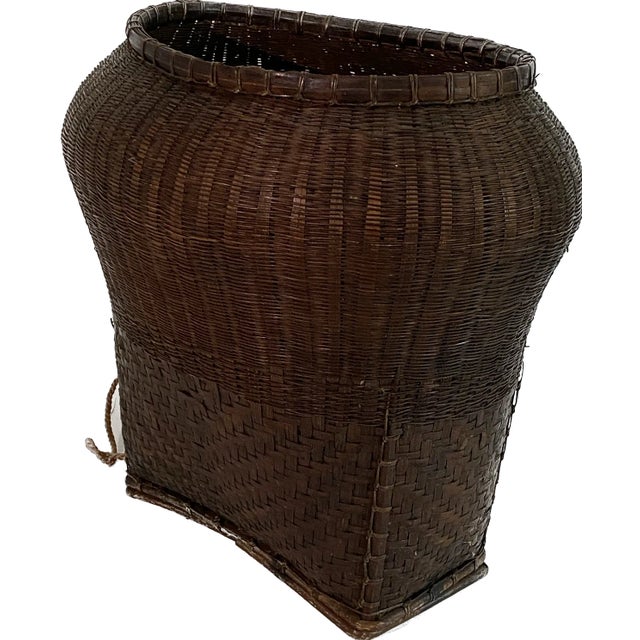This antique Thai Hill Tribe gathering basket has a finely woven rattan body with a wood frame and woven straps. These...