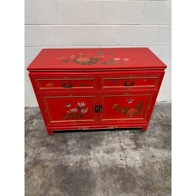 This is a great pop of red! Hand painted floral design. Top two drawers are lined in felt. There is one removable shelf...
