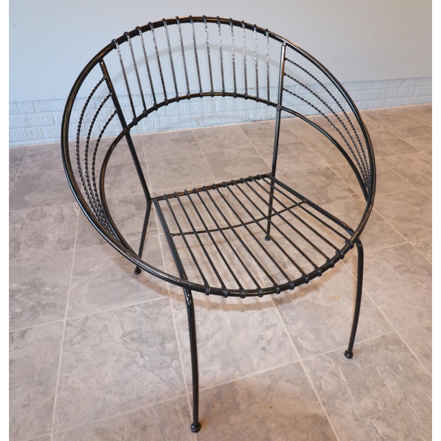 Sculptural pair of mid-century modern wrought-iron hoop lounge chairs dating to the 1950s–1960s. Each chair features a...