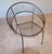 Sculptural pair of mid-century modern wrought-iron hoop lounge chairs dating to the 1950s–1960s. Each chair features a...