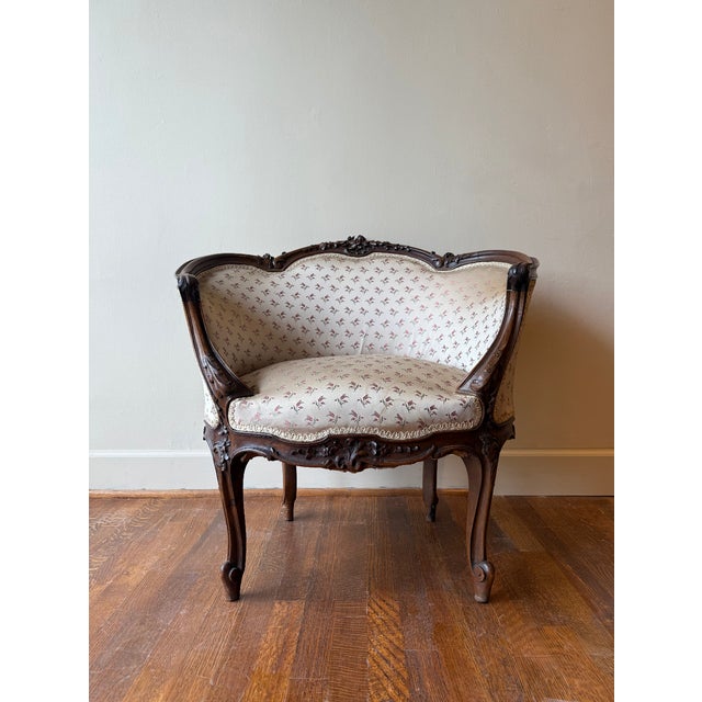 A pair of late 19th-century French Louis XV bergère chairs, finely carved in walnut with floral and rocaille motifs. The...