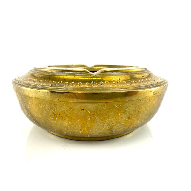 This vintage solid brass ashtray offers old-world character with its substantial, rounded form and deeply etched surface...