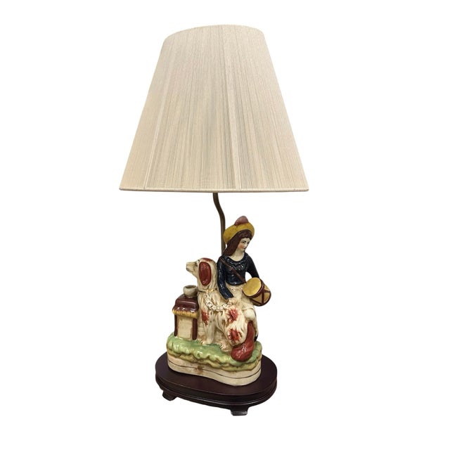 A charming, Staffordshire Pottery style figural lamp. Features a hand painted, pottery figure with a girl holding a drum...