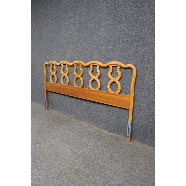 French Provincial king-size headboard featuring a gracefully shaped silhouette with repeating openwork scroll and ring...