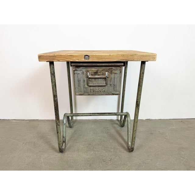 Vintage Industrial worktable from the 1960s. It features an iron construction, a solid wooden plate and an iron drawer....