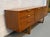 This vintage Mid-Century Modern sideboard was manufactured by Stonehill Furniture in England and features distinctive sled...