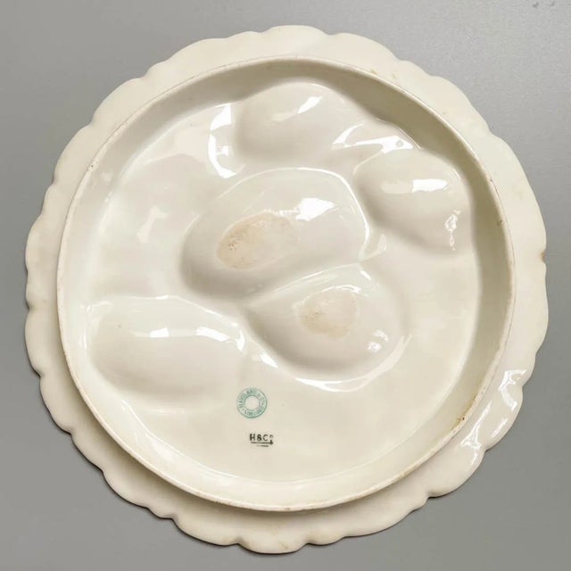 A 19th Century French turkey oyster porcelain plate with five white wells on raspberry pink ground. Decorated with...